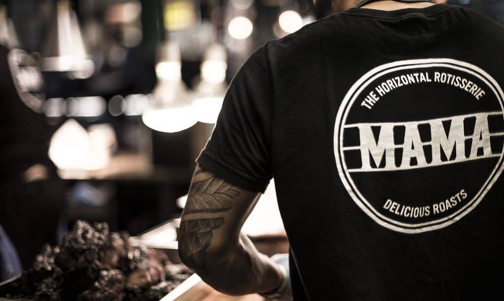 Kock i svart t-shirt med tryckt logotyp på ryggen