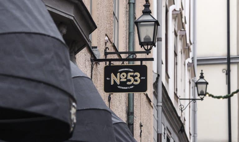Flaggskylt med logotyp på fasad