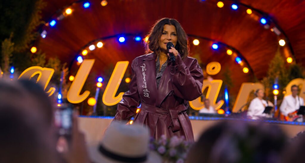 Carola Häggkvist på Allsång på Skansen i kappan med texten Free Woman Song of Joy