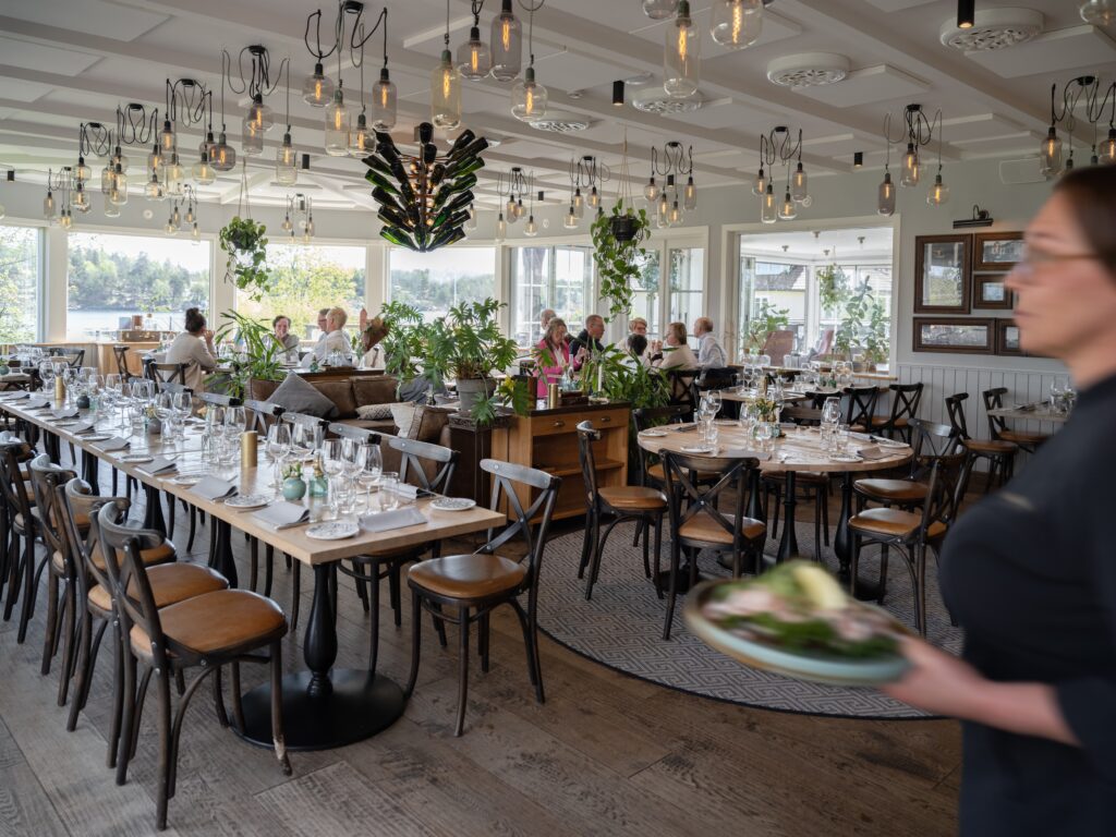 Servering i ljus restaurang med långbord