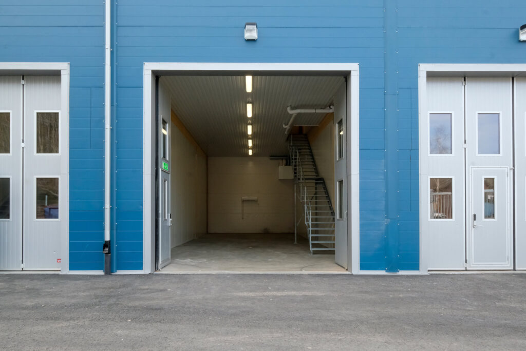 Blå industribyggnad med öppen port