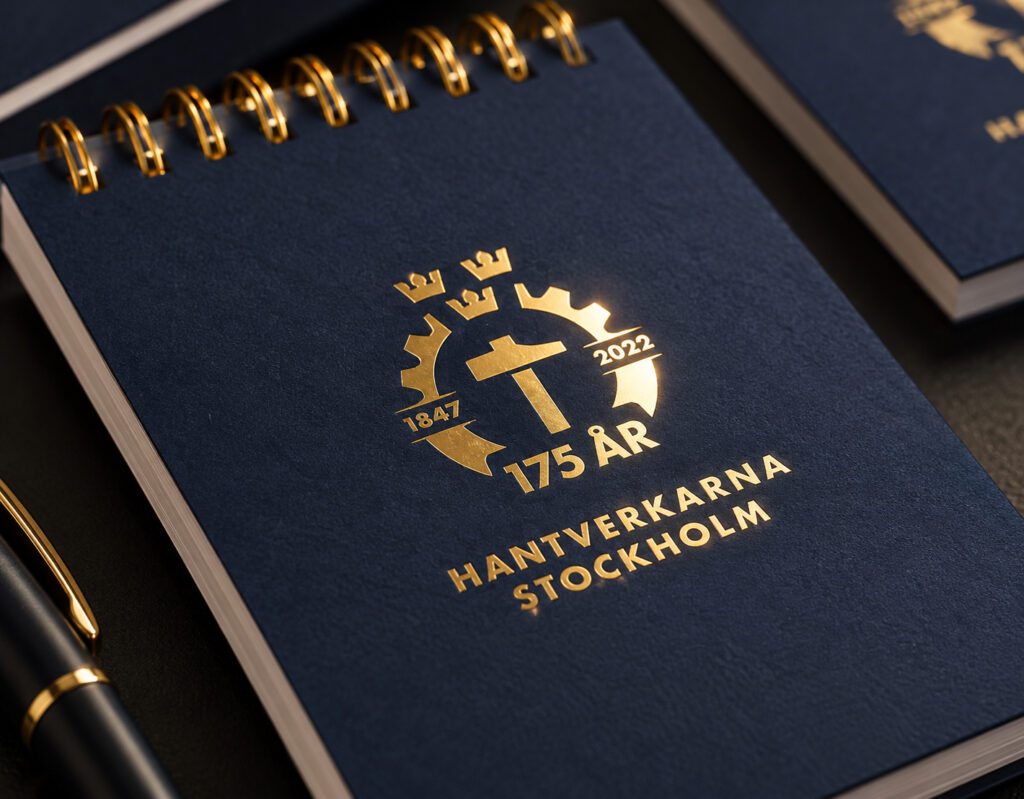 Anteckningsbok för Hantverkarna Stockholms 175-årsjubileum med guldfolie på marinblått omslag
